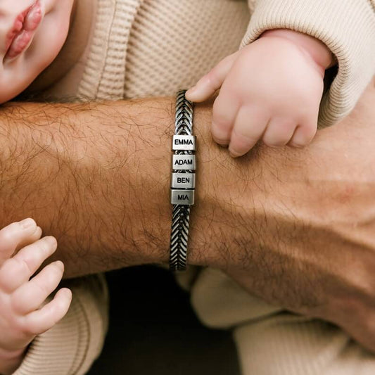 Personalized dad bracelet with engraved family name beads worn by a father with baby