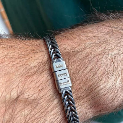Silver personalized bracelet with engraved family name beads on a man's wrist