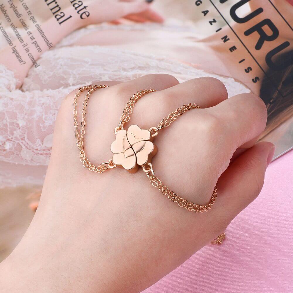 Hand wearing a magnetic heart charm bracelet that connects with three other matching pieces.