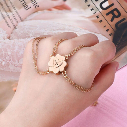 Hand wearing a magnetic heart charm bracelet that connects with three other matching pieces.